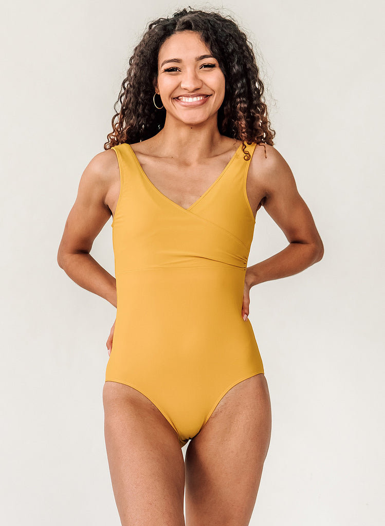 Photo of woman wearing a yellow one piece swimsuit