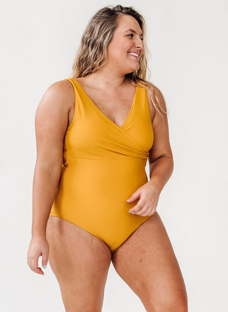 Photo of a woman wearing a yellow one piece swimsuit