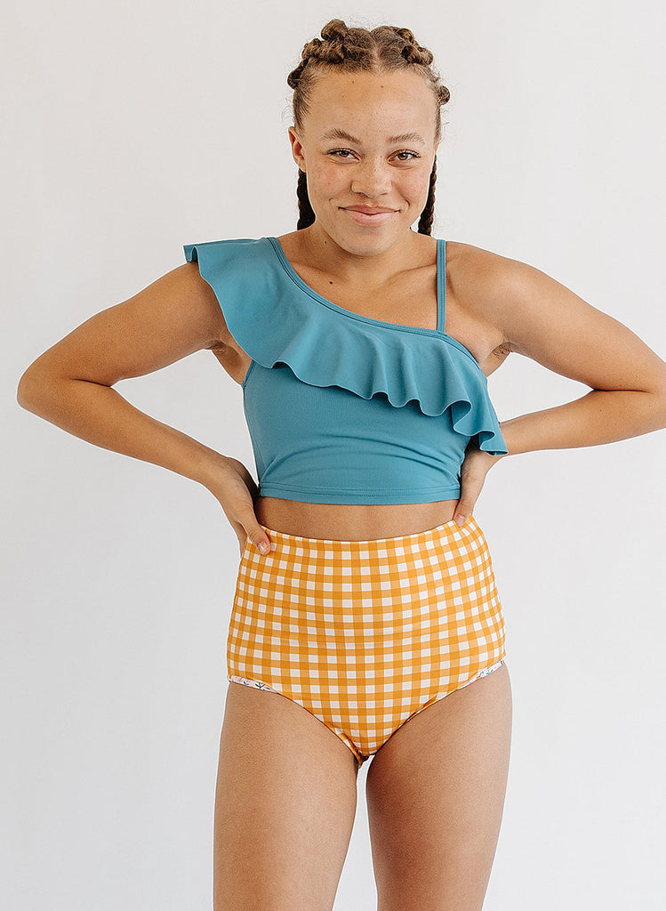 Photo of woman wearing blue ruffle cropped swim top with yellow and white gingham swim bottoms