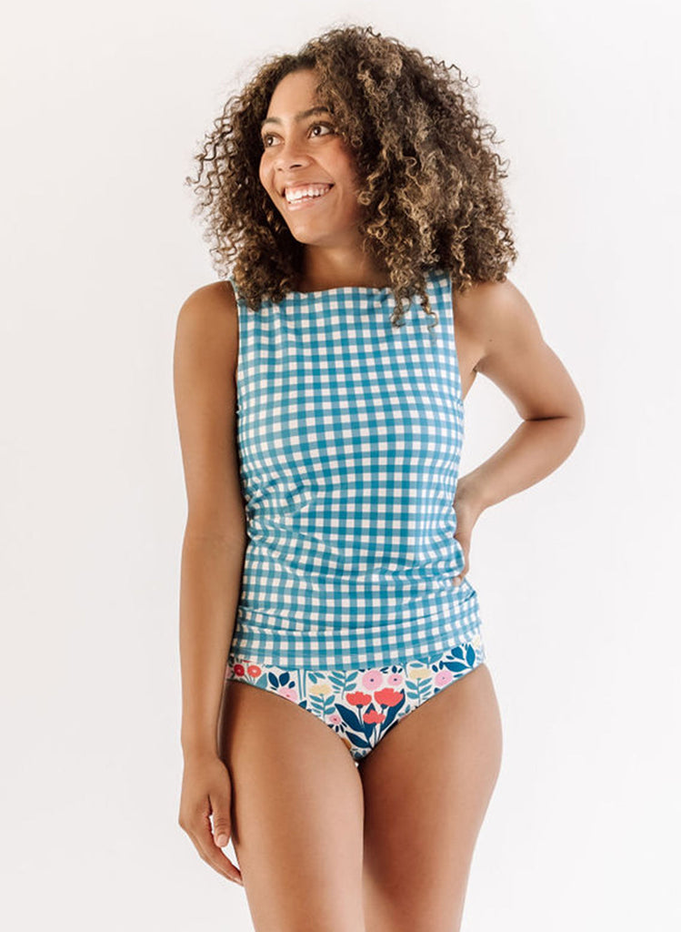 Photo of a woman wearing an Ocean Gingham boat-neck swim top and a May flowers swim bottom