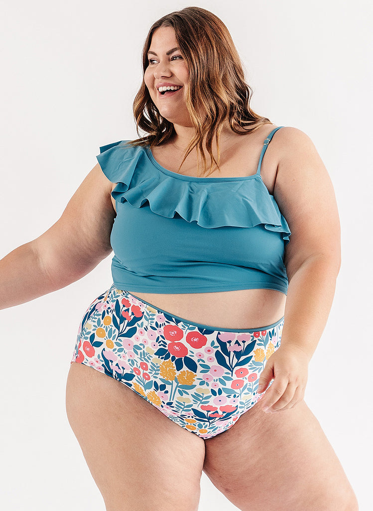 Photo of woman wearing blue ruffle cropped swim top with multi color floral swim bottoms