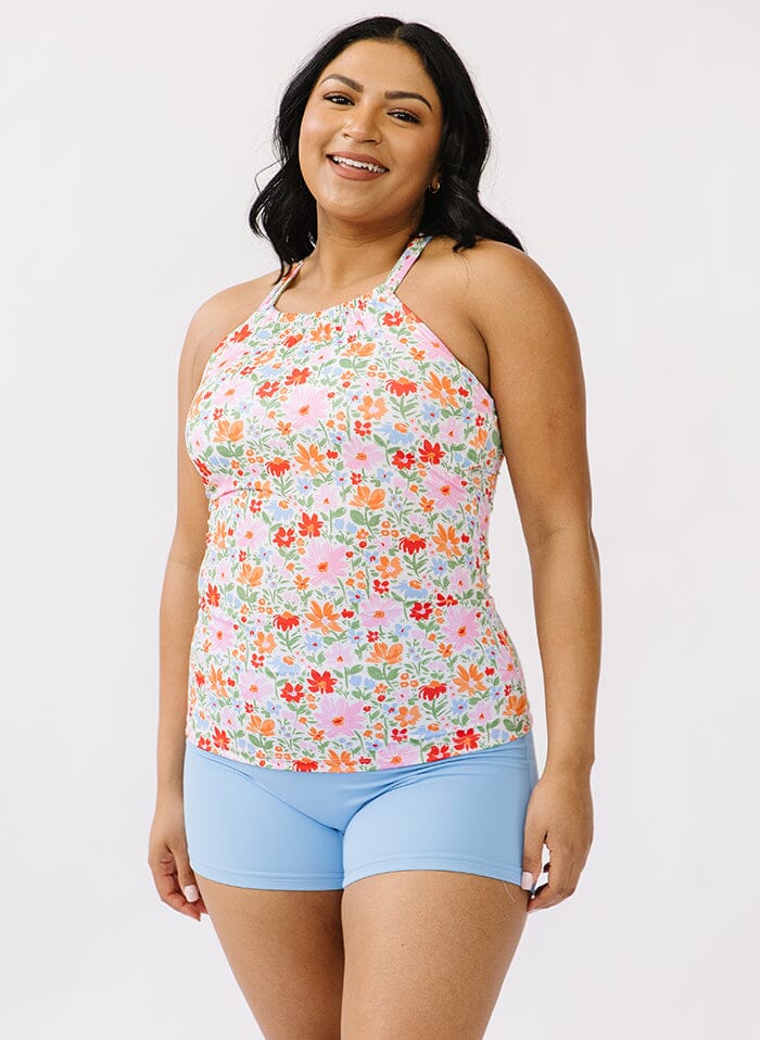 Photo of a woman wearing a floral double cinch swim top and a blue swim short bottom