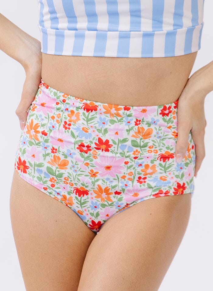 Photo of a woman wearing peri stripe/ multi color floral reversible swim bottom floral side