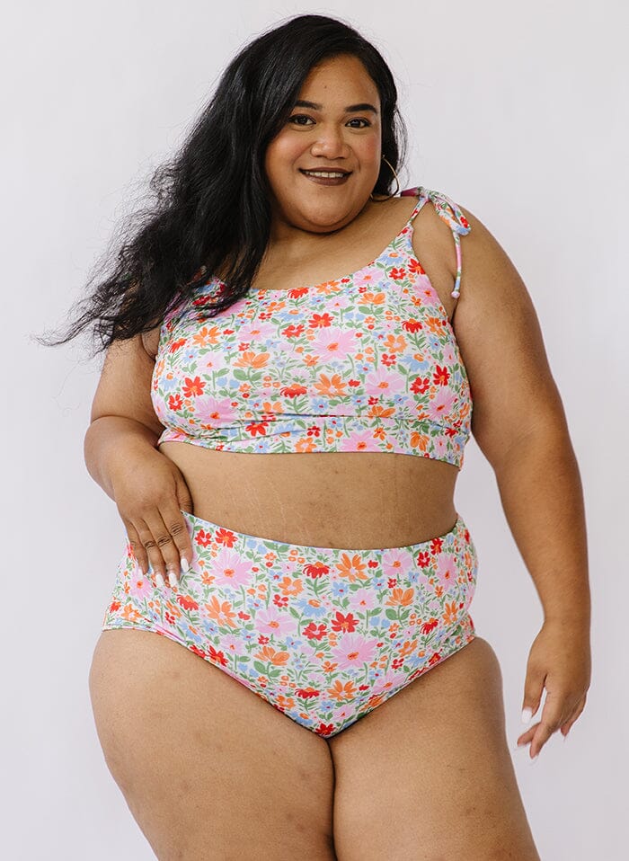 Photo of a woman wearing peri stripe/ multi color floral reversible swim bottom floral side and a floral shoulder-tie swim crop top