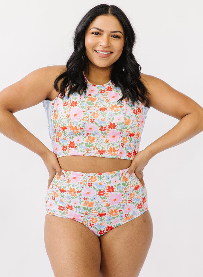 Photo of a woman wearing a multi color swim crop top and floral swim bottoms