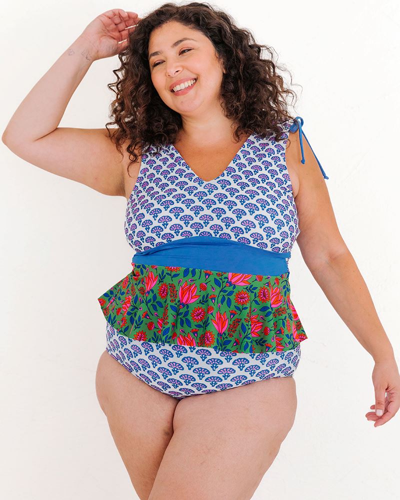 Photo of a woman wearing a Block Floral/ Fresco Floral reversible swim bottom Block floral side and a multi color peplum swim top