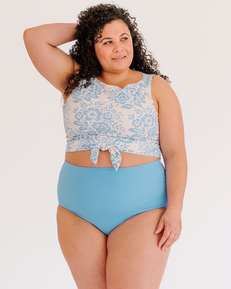 Photo of a woman wearing a Peri Lace/ Peri reversible swim bottom Peri side and a Peri Lace swim crop top