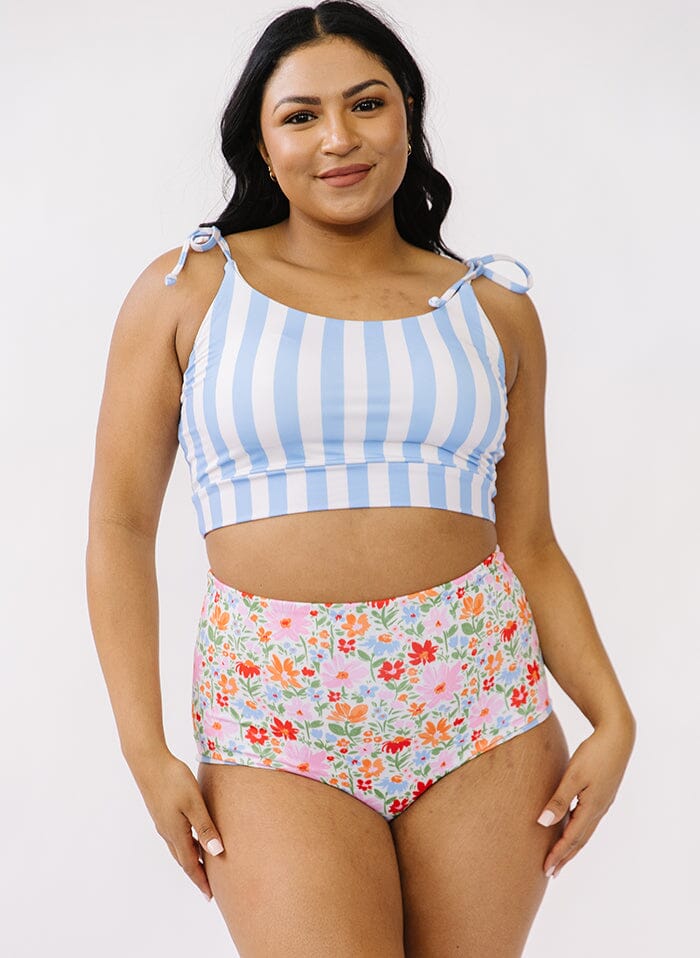 Photo of a woman wearing a peri stripe shoulder-tie swim crop top and a floral swim bottom