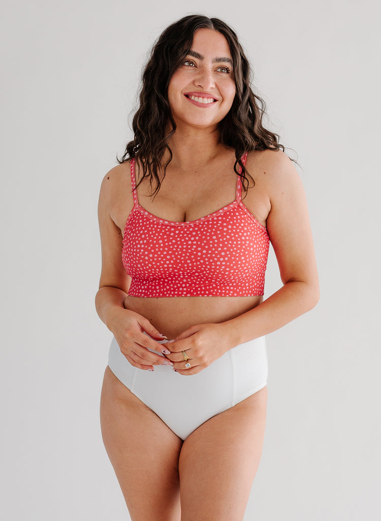 Photo of woman wearing pink dot bralette swim top with white swim bottoms