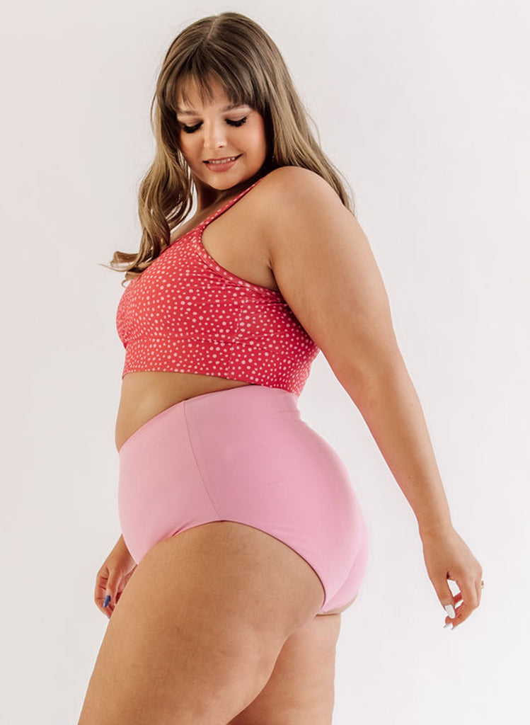 Photo of woman wearing pink dot bralette swim top with pink swim bottoms side angle