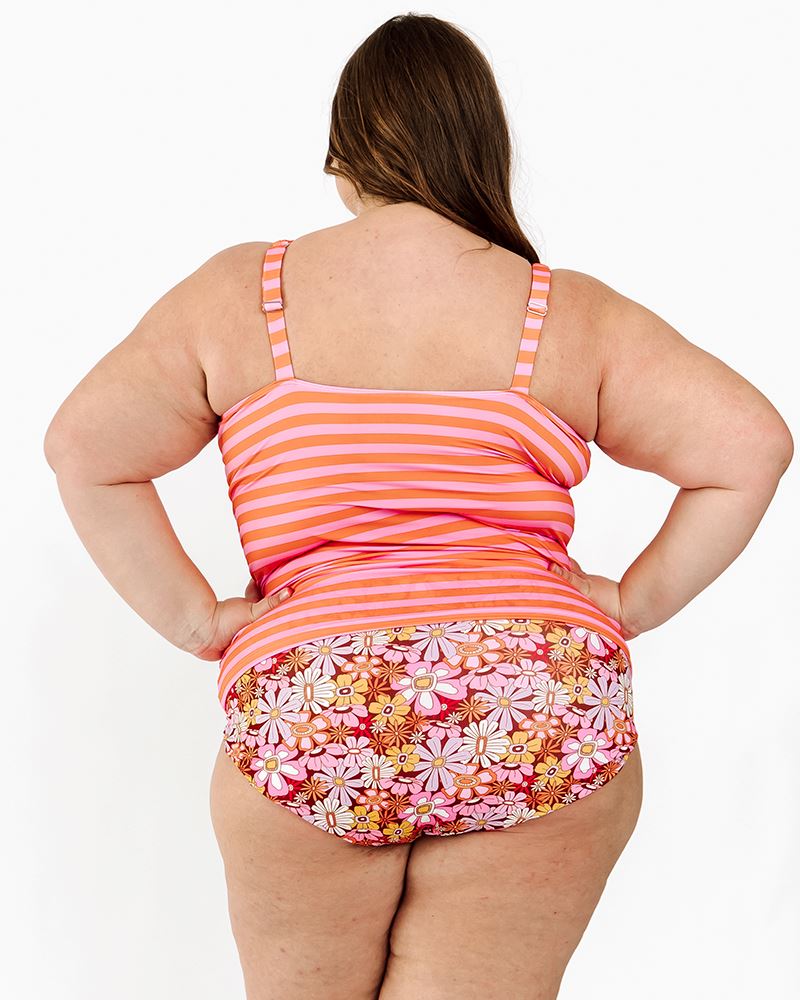 Photo of a woman wearing a Sherbet stripe square neck swim top and a groovy blooms floral swim bottom back angle