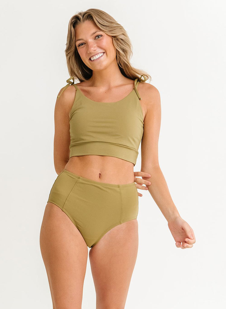 Photo of woman wearing green cropped swim top with green swim bottoms