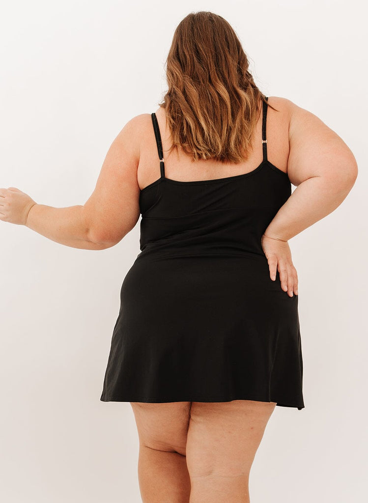 Photo of a woman wearing a black swim dress back angle