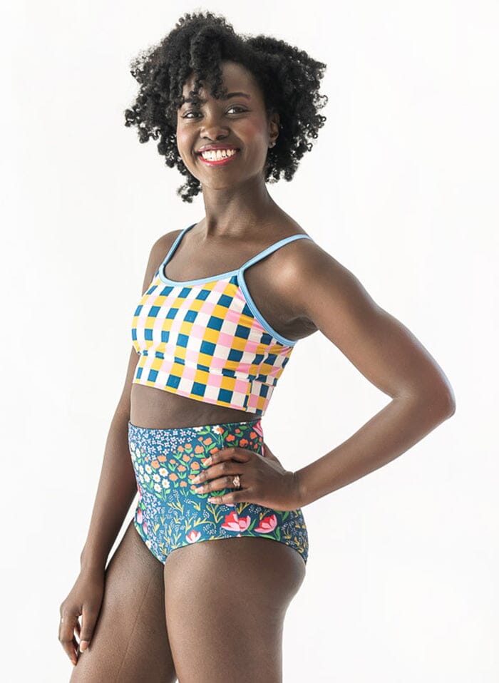of a woman wearing a Blixen/Indigo reversible swim bottom floral side and a multi color checkered swim bralette side angle
