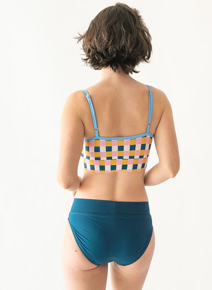 Photo of a woman wearing an Indigo classic swim bottom and a multi color checkered swim bralette back angle