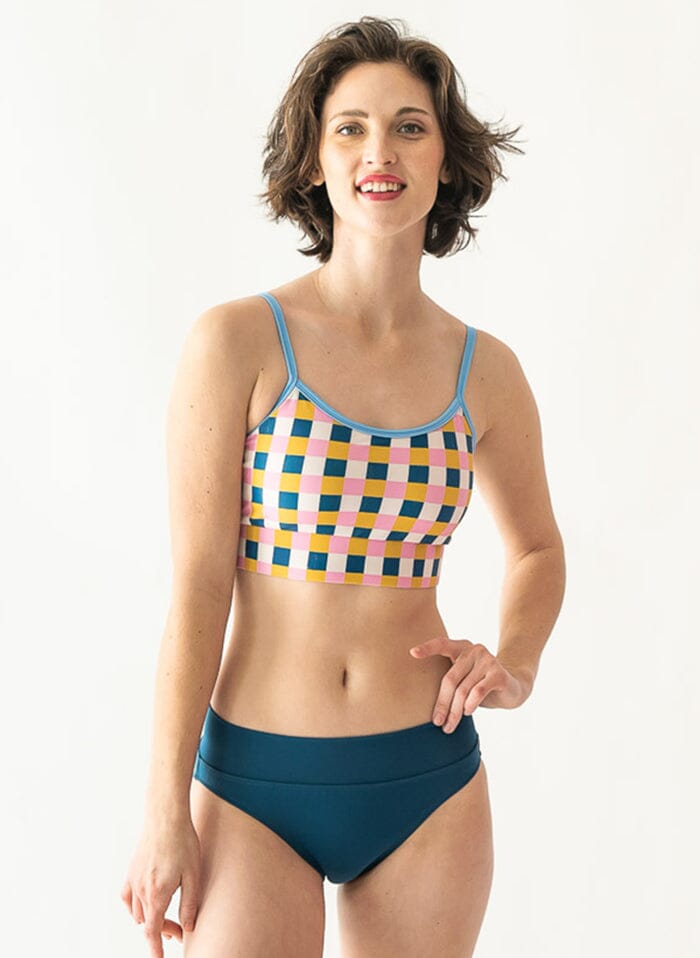 Photo of a woman wearing an Indigo classic swim bottom and a multi color checkered swim bralette