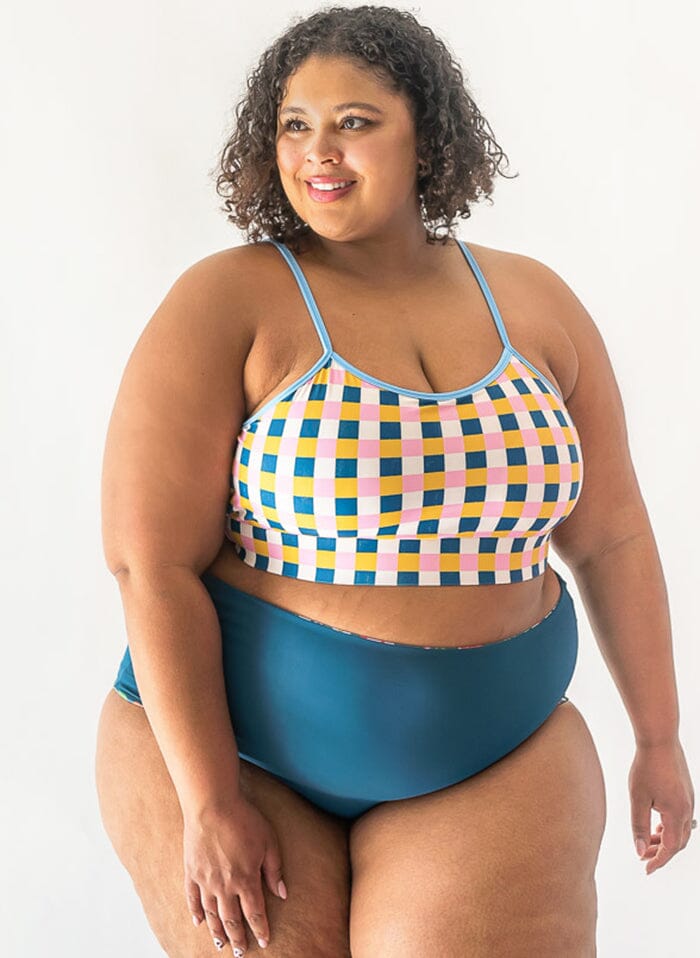 Photo of a woman wearing a multi color swim bralette and an indigo swim bottom