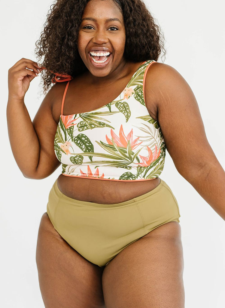 Photo of woman wearing a green floral cropped swim top with green high waist bottoms