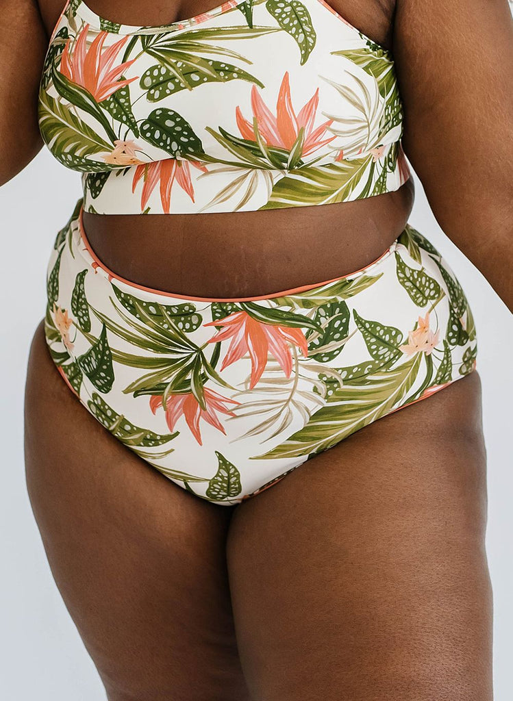 Close up photo of a woman wearing a green floral cropped swim top with green floral high waist swim bottoms