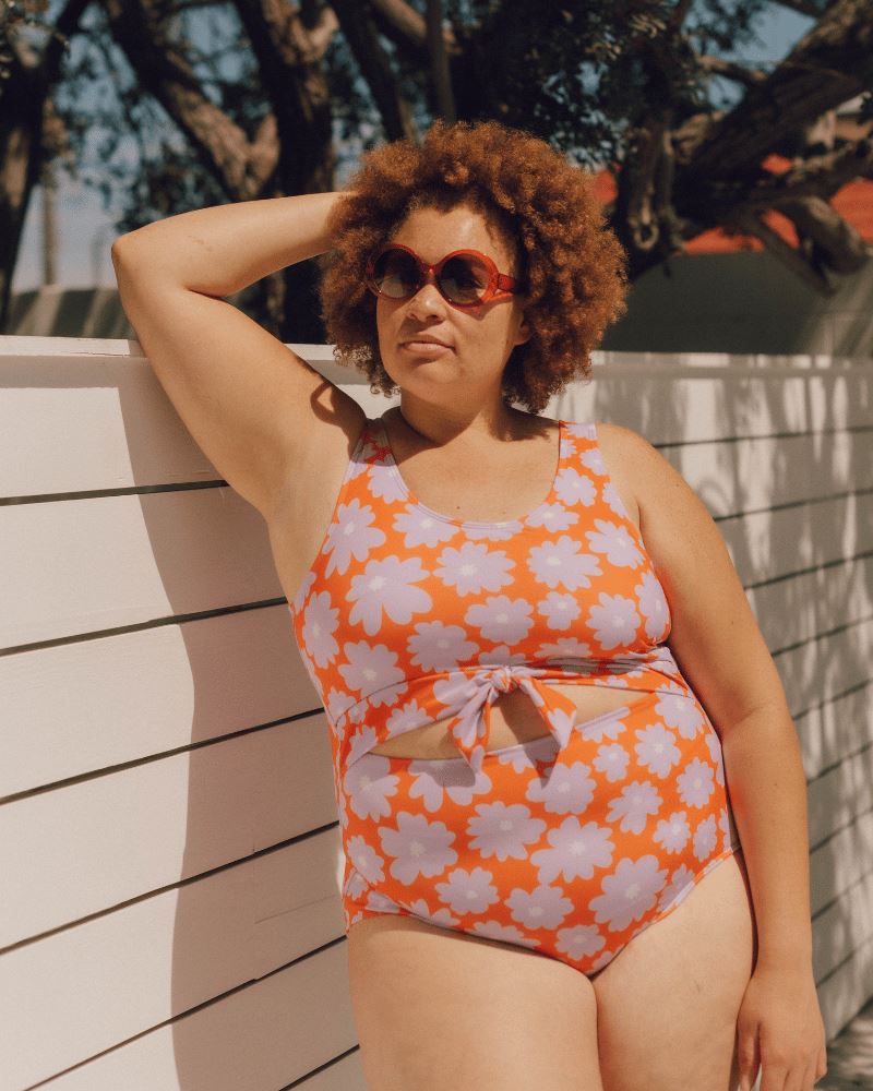 Photo of a woman wearing a Daphne floral knotted one-piece swim suit